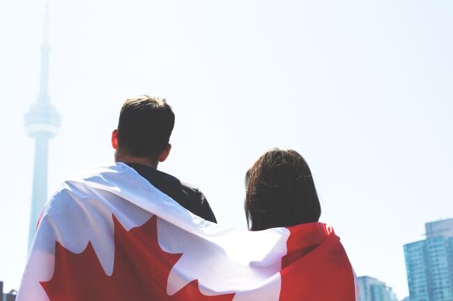 Man and woman wrapped in Canadian flag